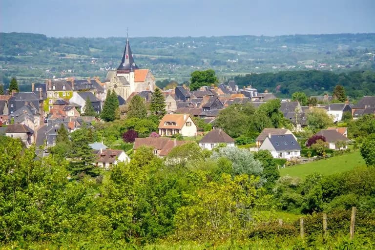 Charming French village with stone houses, church spire, and lush green countryside landscape